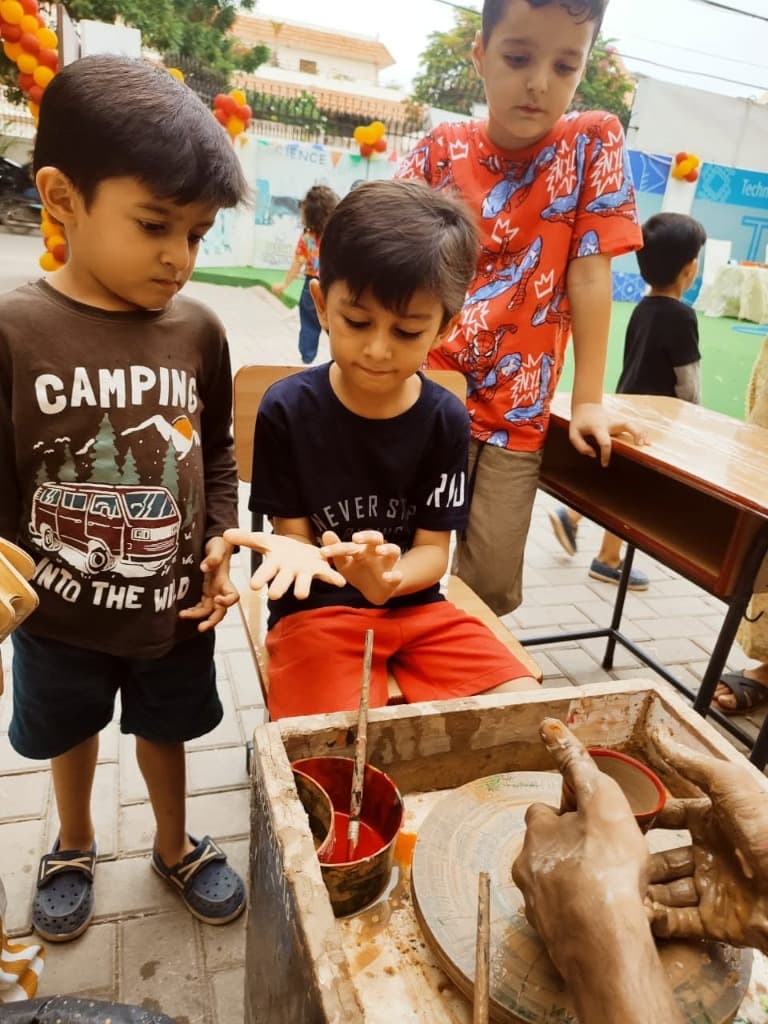 Children observing the spin speed and clay textures during the school workshop