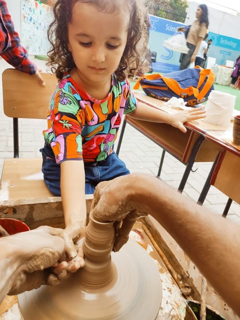 Girl molding clay cylinder
