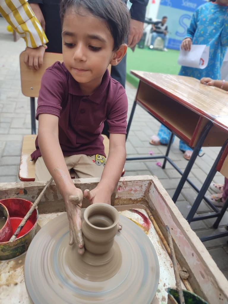 Student handcrafting clay cup